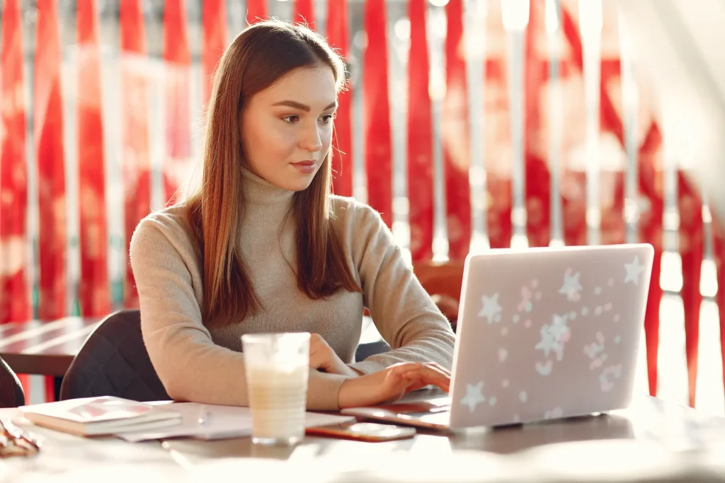 A person working on a laptop writing a blog post on a desk